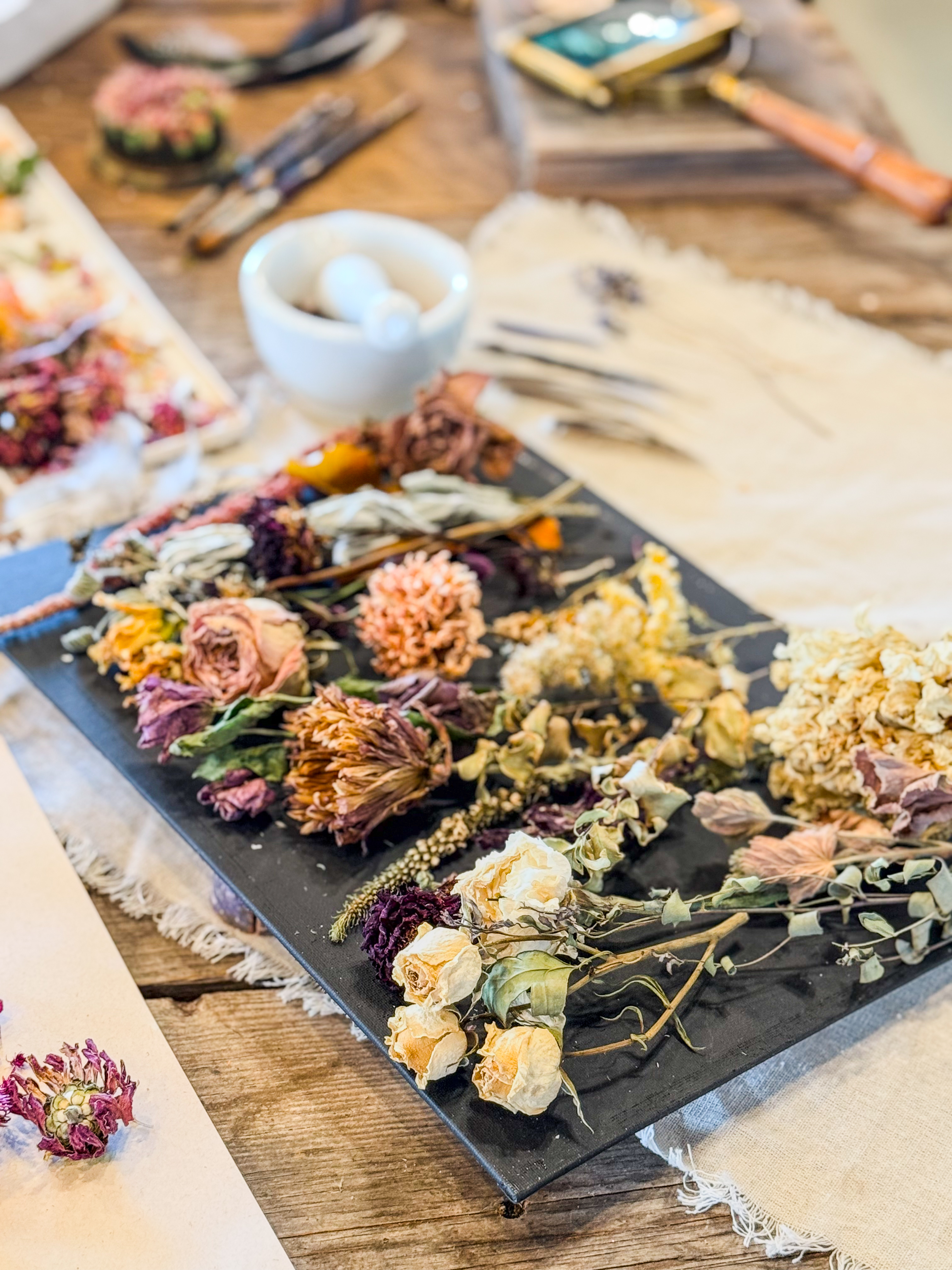 Mortar and pestle with dried lavender sprigs and feathers on linen — the apothecary at rest