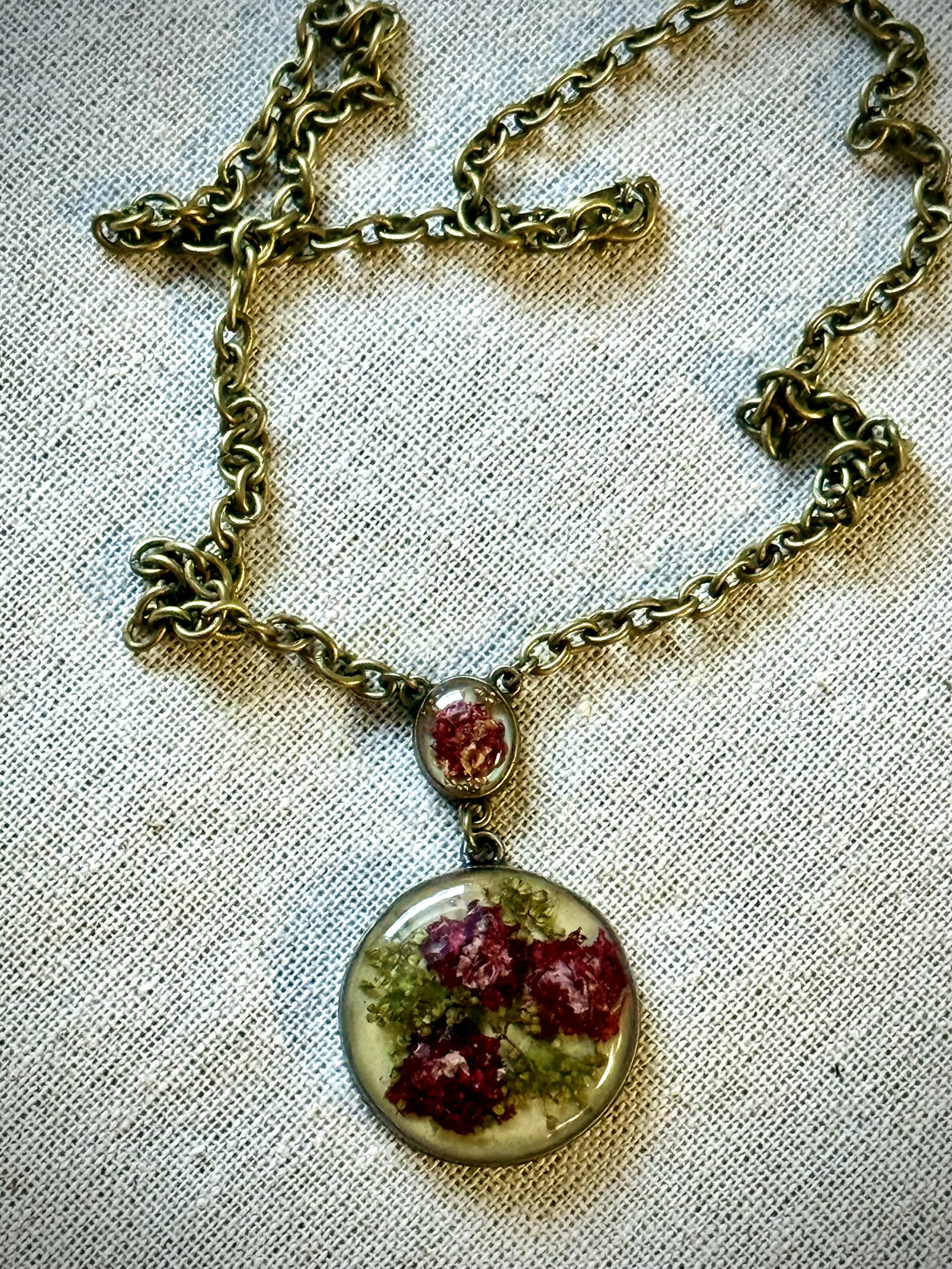 Double pendant necklace on antique brass chain, crimson pixelated blooms