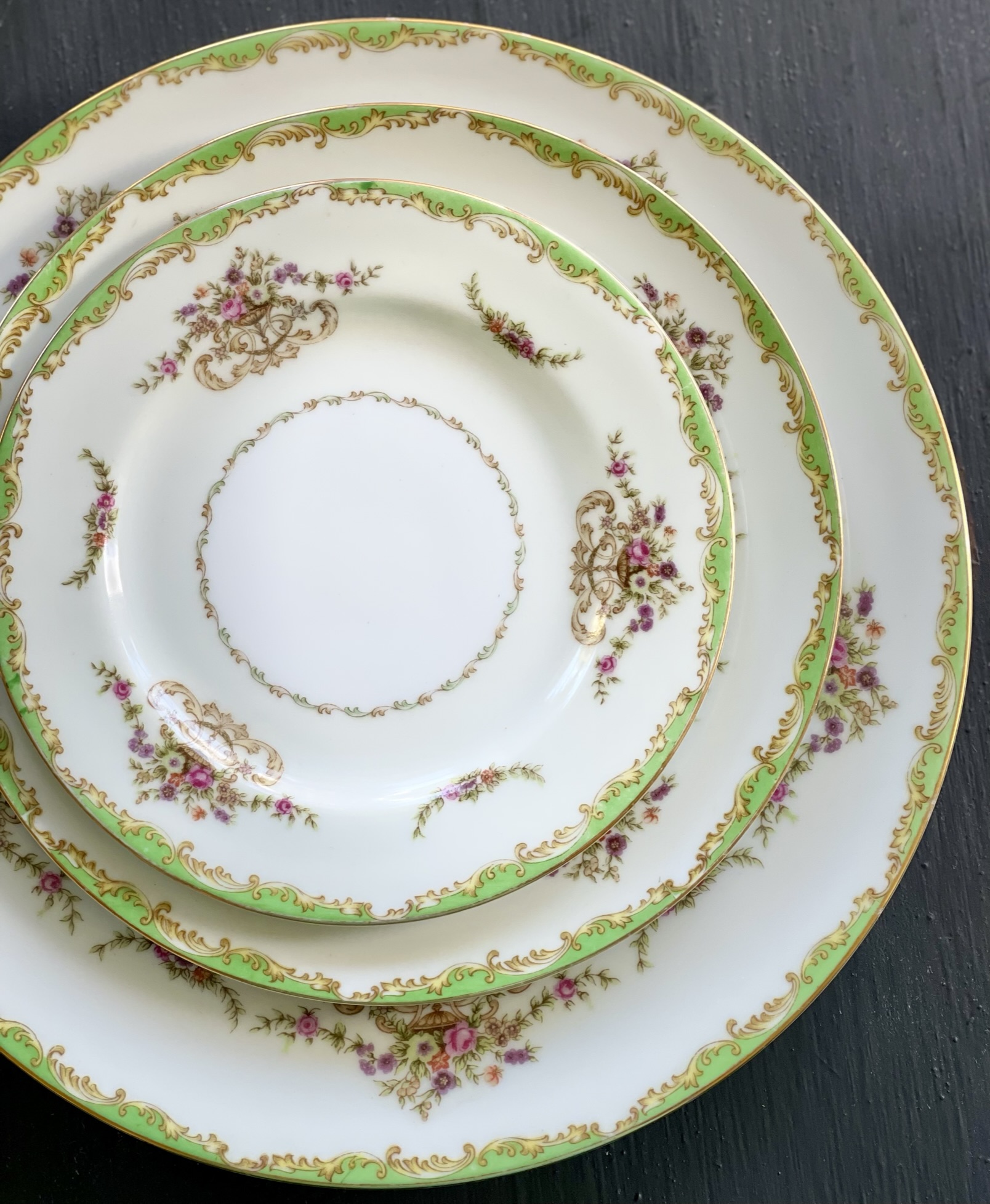 A theatrical lime-green and heavy-gold rococo formal pattern with small pink and purple flower sprays on cream plates