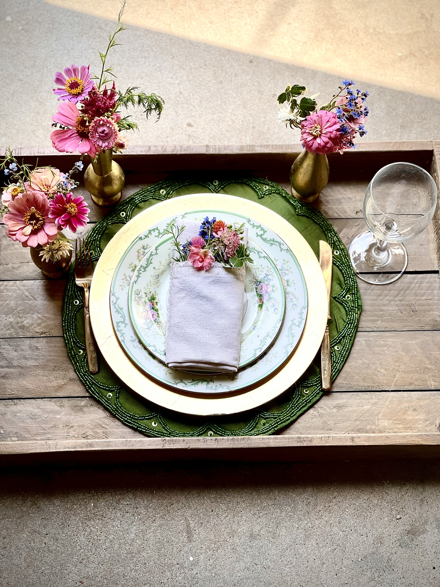 A formal place setting with stacked vintage china — plate, saucer, bread plate layered together