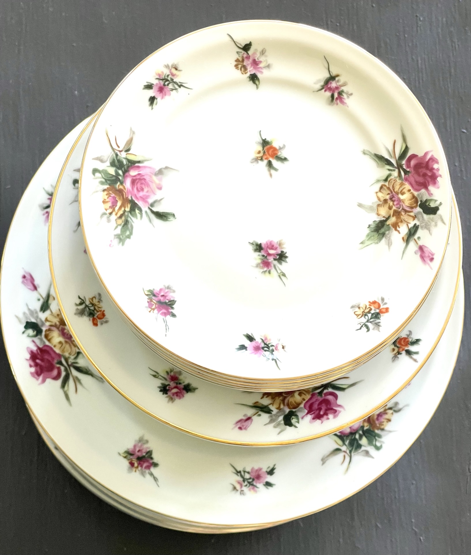 Rosalinde by Theodore Haviland — pink roses and golden chrysanthemums floating untethered across cream-white plates stacked in three sizes