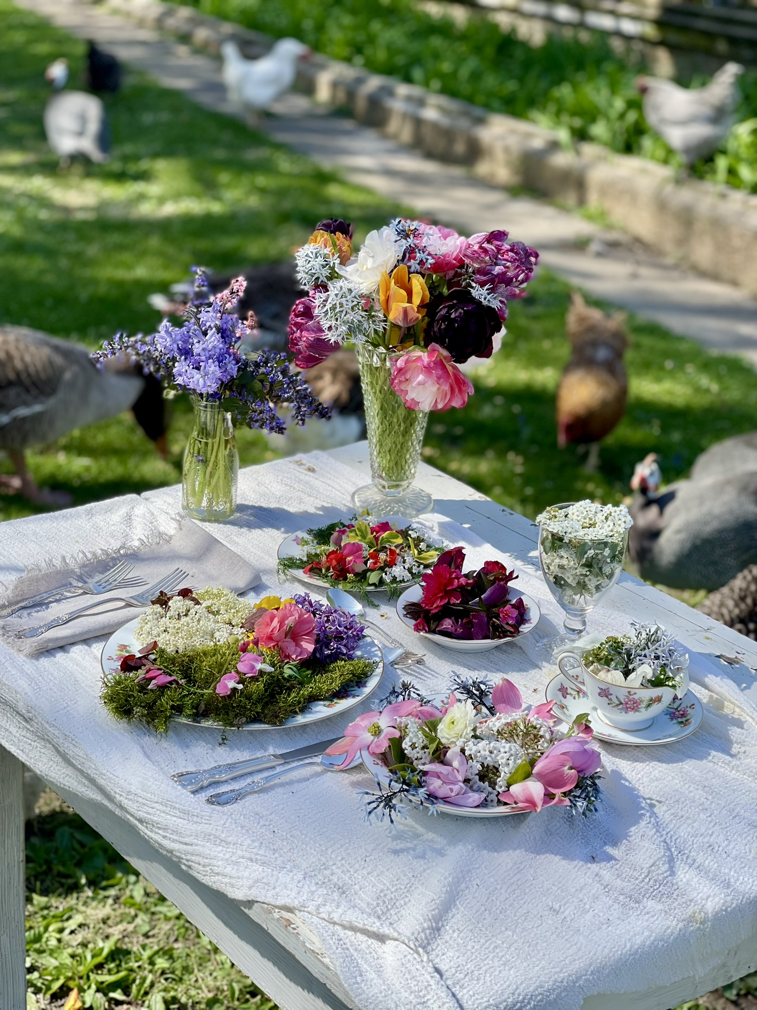 The full farmyard table with guinea fowl, chickens and turkeys roaming in the background — the whole scene from a distance