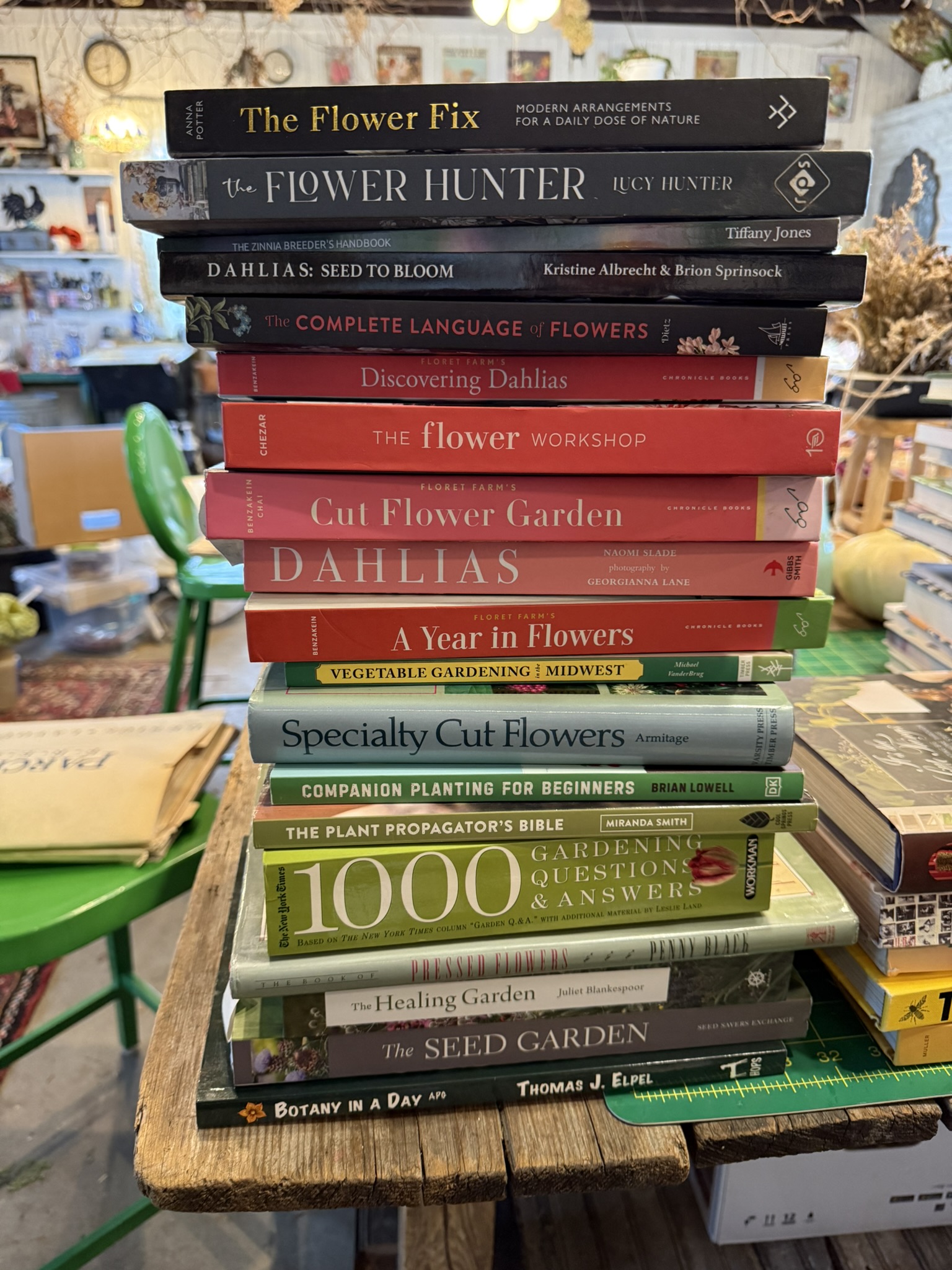 A towering stack of botanical and flower books on the studio worktable