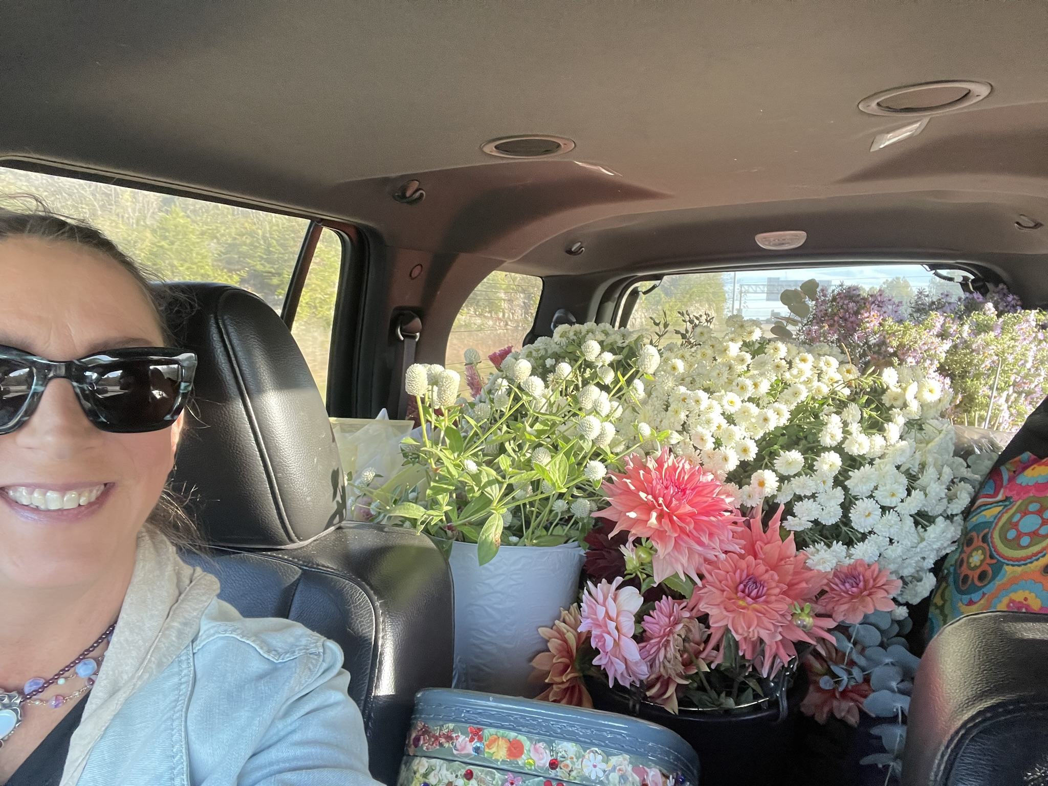 Car selfie: Luli driving to the venue with the back seat packed with white mums and dahlias