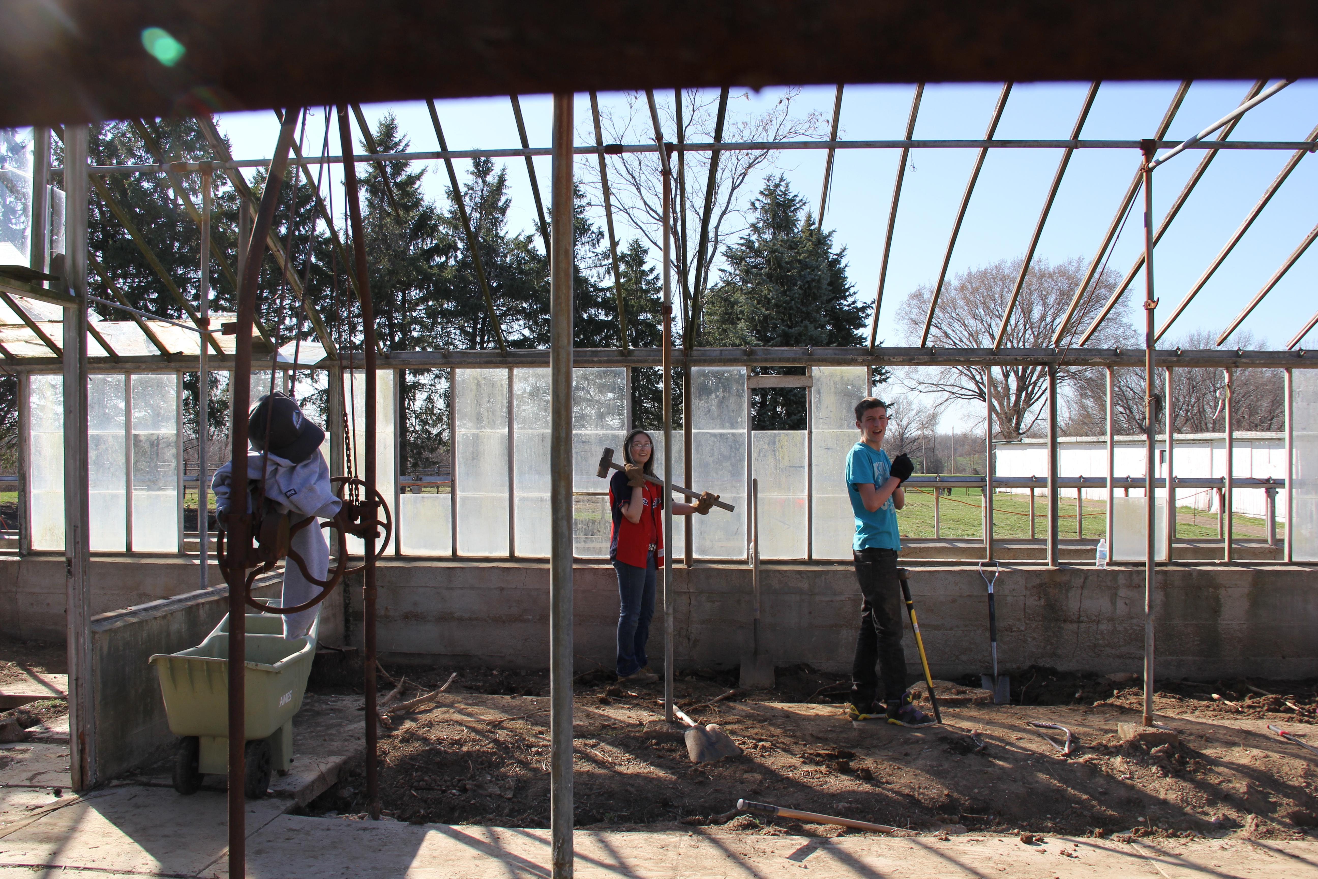 The beginning of the restoration — friends with sledgehammers and rakes working inside the stripped frame