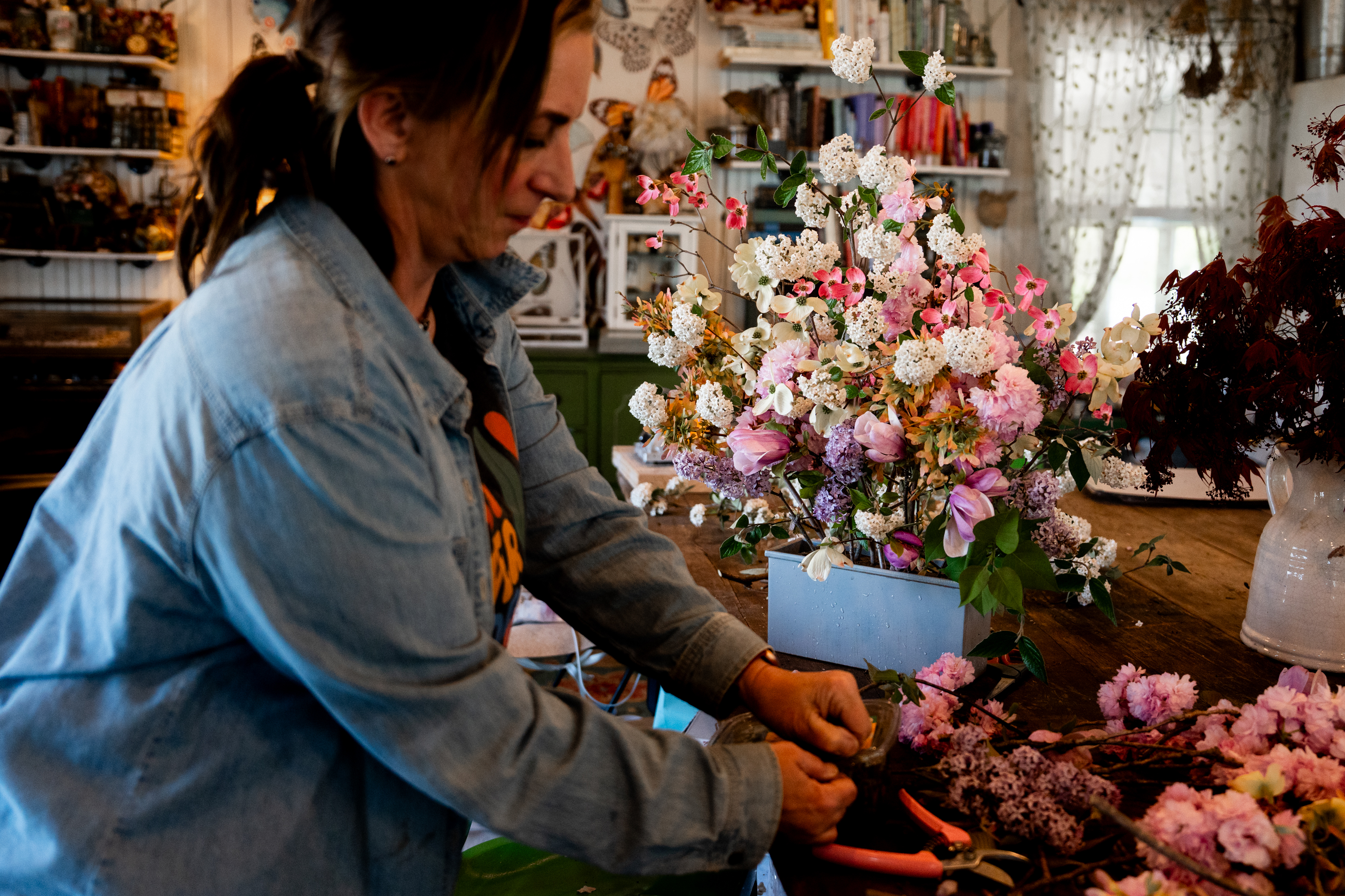 Luli at the worktable, hands in flowers